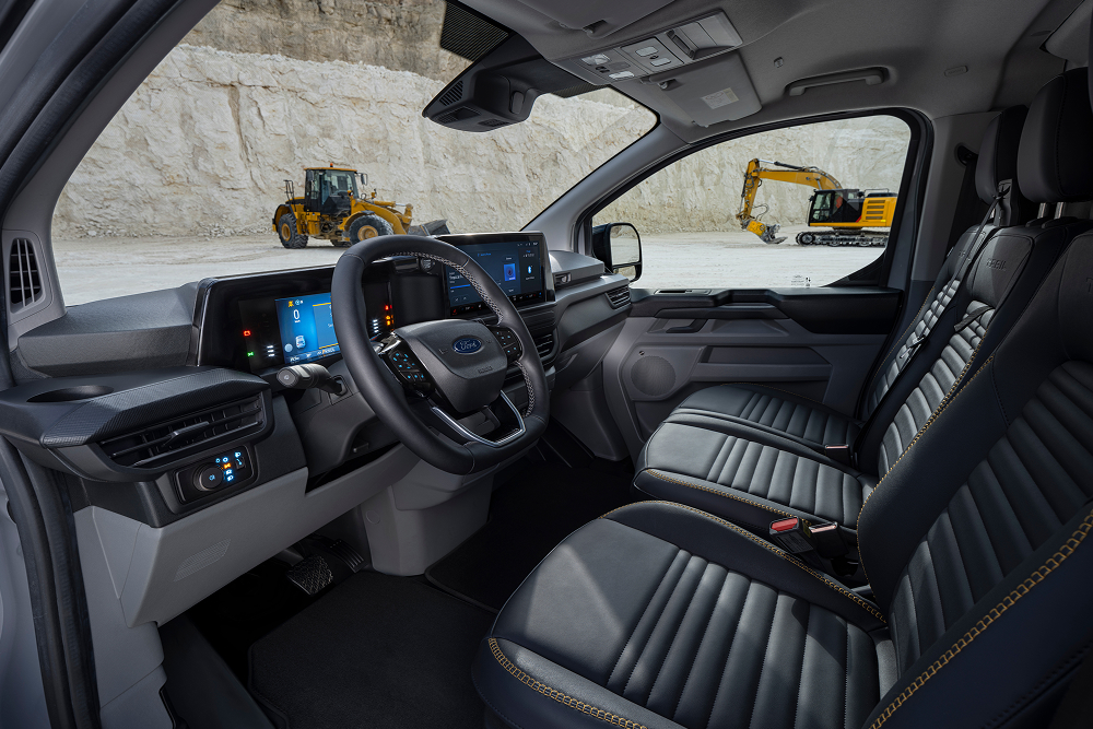 Vnitřek elektrické dodávky Ford E-Transit Custom zaparkované v lomu s vyobrazením sedadel a volantu. 