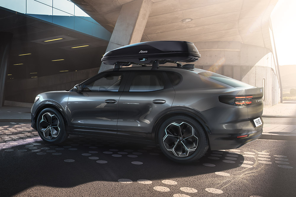 Stříbrný Ford zaparkovaný před luxusní moderní budovou.