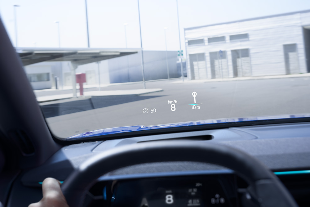 Pohled na volant a ven skrz čelní sklo z interiéru vozu Ford.
