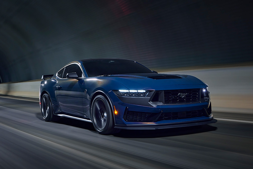 Mlhavě modrý sportovní vůz Ford Mustang projíždějící tunelem.