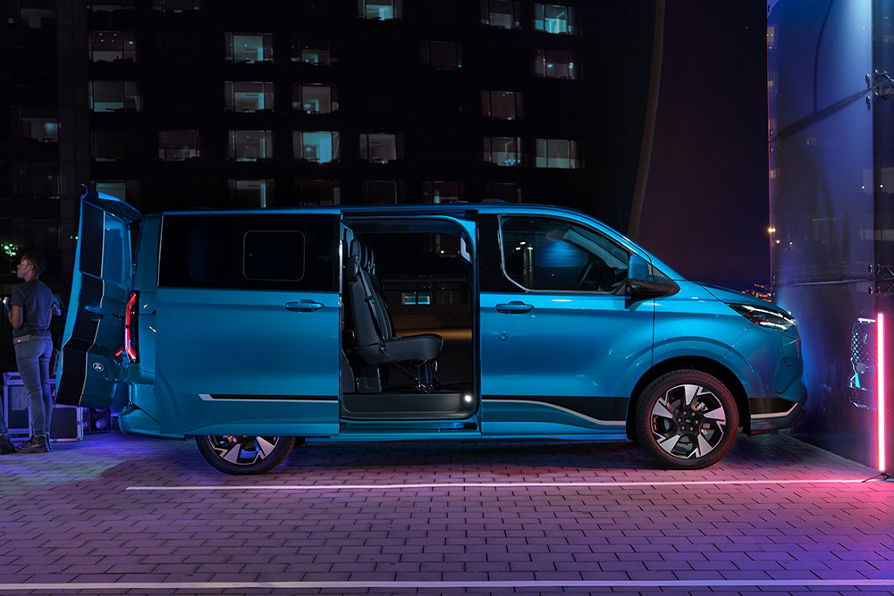 Modrá elektrická dodávka Ford E-Transit Custom DCiV s otevřenými dveřmi.