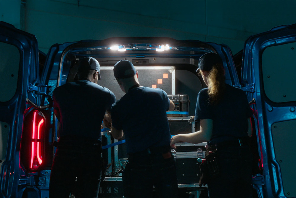 Tři lidé pracující v zadní části dodávky Ford Transit Custom.