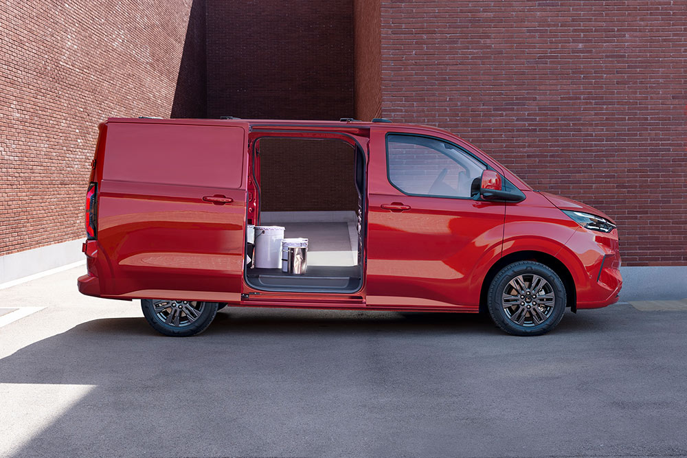 Červená dodávka Ford Transit Custom s otevřenými bočními posuvnými dveřmi na obou stranách.