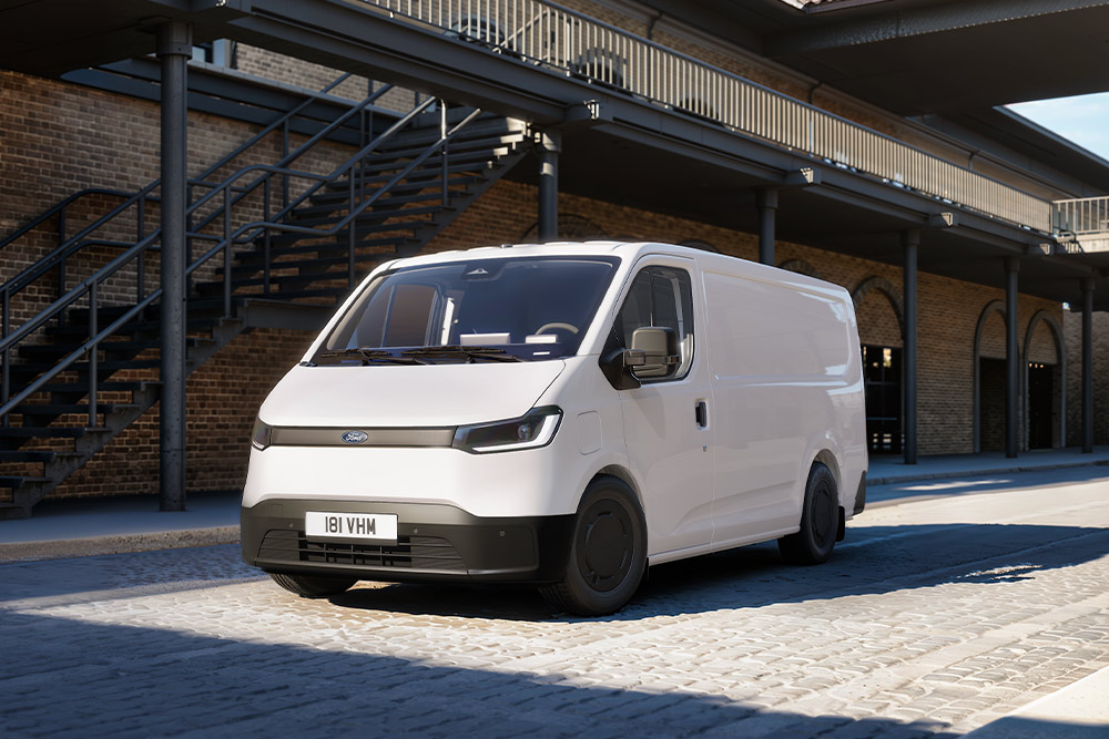 Bílá dodávka Ford Transit City® L1H1 zaparkovaná před cihlovou budovou.