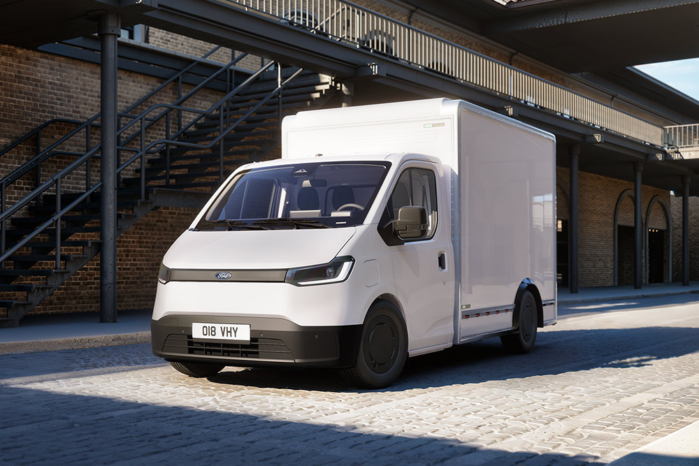 Bílá dodávka Ford Transit City® podvozek s kabinou zaparkovaná před cihlovou budovou.