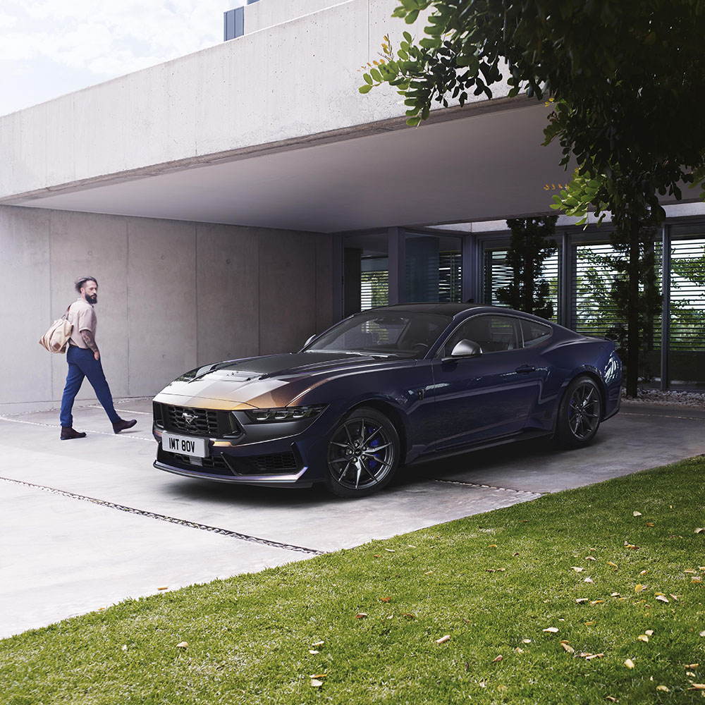 Ford Mustang v modré Ember zaparkovaný na příjezdové cestě.